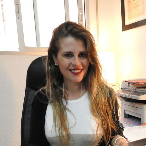 Berta Estrada Vidal, abogada, sentada en su sillón de despacho en Melilla y sonriendo a cámara